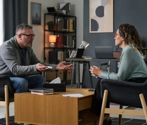 discussing-project-modern-office-setting-two-people-sitting-across-each-other-modern-office-engaging-conversation-330437599